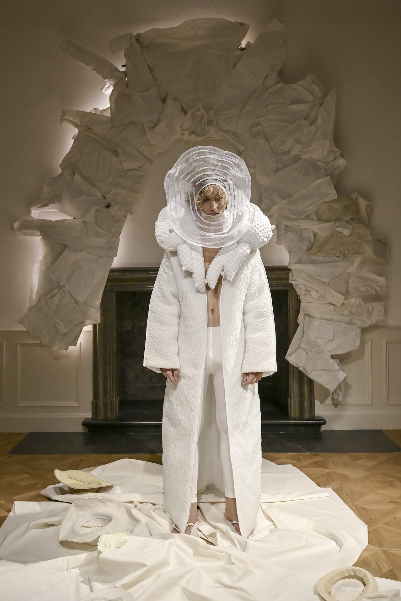 A sculptural white hood and long garment are presented at the ANTICON performance.